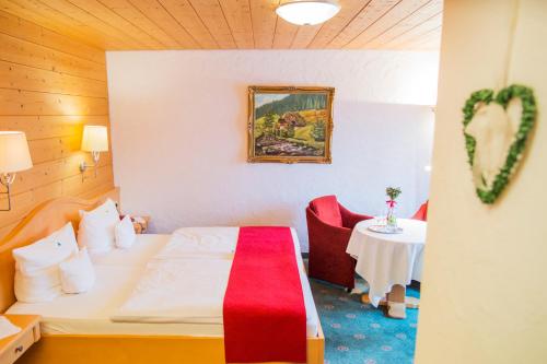 a hotel room with a bed and a table at Kaisers Tanne - Premium Alles Inklusive Hotel in Breitnau