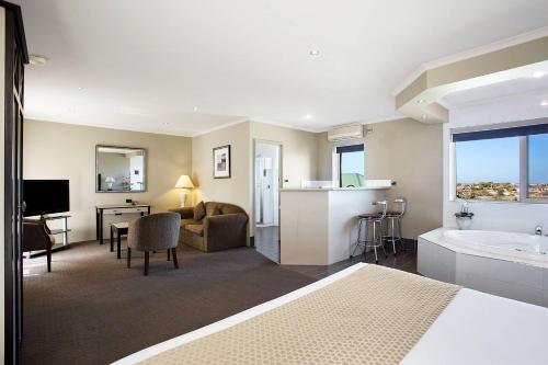 a hotel room with a bed and a bathroom at Comfort Inn On Raglan in Warrnambool
