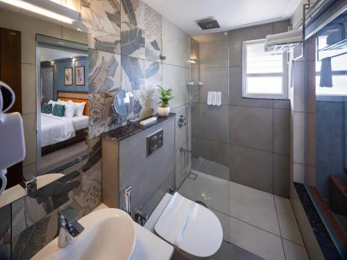 a bathroom with two sinks and a toilet in a room at Hill Seasons Resorts and SPA in Tindummal