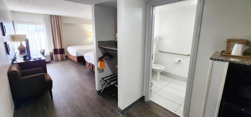 a hotel room with a bathroom with a bed at Comfort Inn Pensacola - University Area in Pensacola
