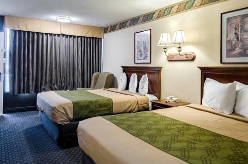 a hotel room with two beds and a window at Rodeway Inn Vicksburg in Vicksburg