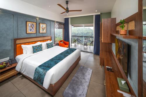a bedroom with a large bed and a balcony at Hill Seasons Resorts and SPA in Tindummal