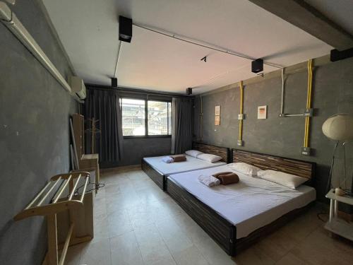 a bedroom with two beds and a chair in it at Brio Cafe and Hostel in Godown