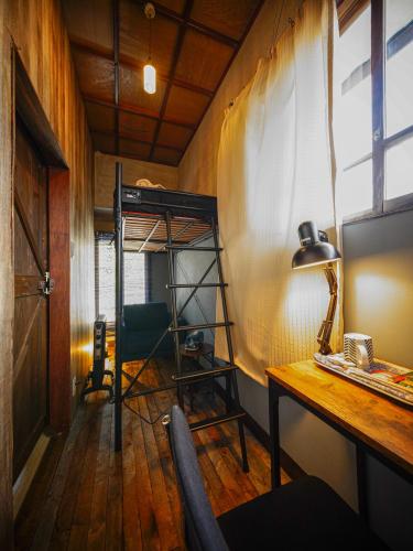 a room with a desk and a bunk bed at Wonderlust Inn in Kamakura