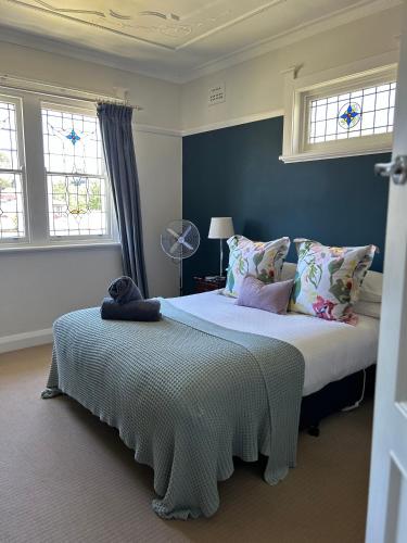 a bedroom with a large bed and two windows at Lurline Villas in Katoomba