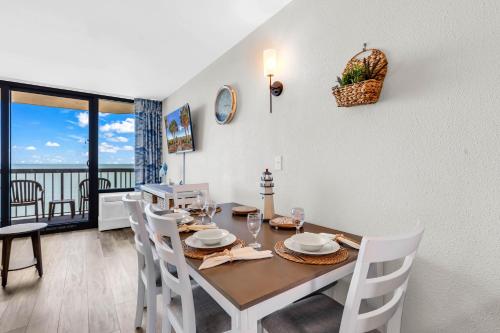 a dining room with a table and chairs and a balcony at Compass Cove 1466 in Myrtle Beach