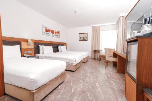 a hotel room with two beds and a television at ARMİS HOTEL in İzmir