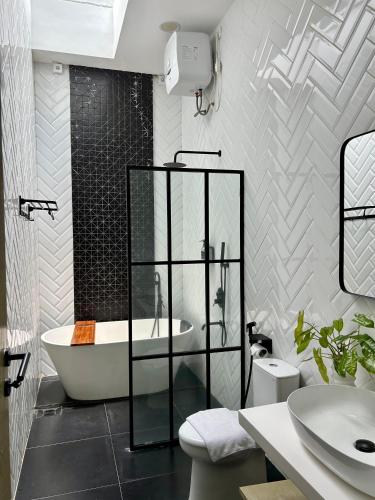 a bathroom with a tub and a toilet and a sink at Gauri Vasanta Villa with Private Pool Yogyakarta in Yogyakarta