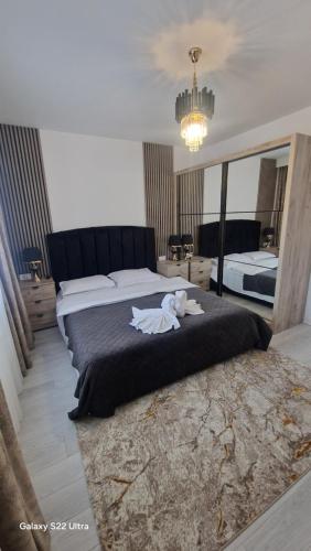 a bedroom with a large bed with a stuffed animal on it at Apartament EVA in Suceava