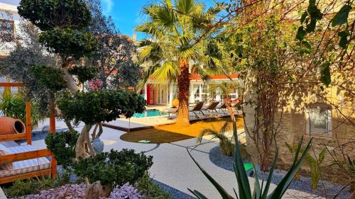a house with a garden with palm trees at Jardin d'Azur Alaçatı in Alaçatı