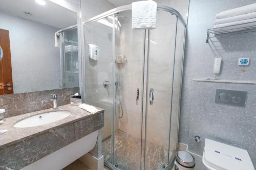 a bathroom with a shower and a sink at ARMİS HOTEL in İzmir