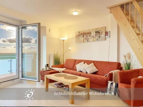 a living room with a couch and a table at Ferienwohnung de Lark Penthouse mit Nordseeblick in Dorum-Neufeld