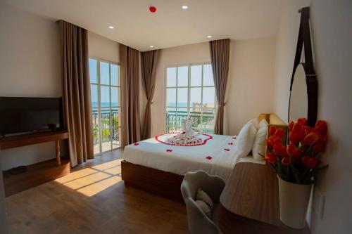 a bedroom with a bed with flowers and a television at Hotel Kim Thái in Phú Quốc