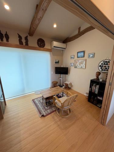 a living room with a table and a large window at Sakura house in Kyoto