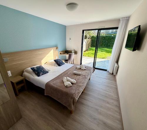 a bedroom with a bed with towels on it at Logis Hôtel Au Moyne de Saire in Réville