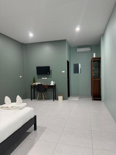 a living room with a bed and a desk at Third Space House in Ban Chak Phak Kut