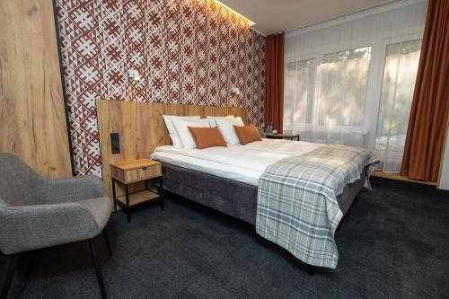 a bedroom with a bed and a chair in it at Värska Veekeskuse hotell in Väike-Rõsna