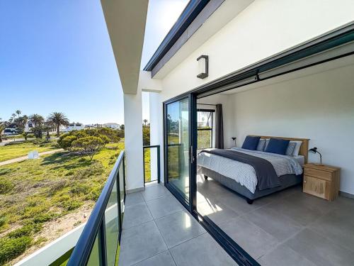 a bedroom with a bed on a balcony at Grace Eleven in Stompneusbaai