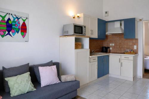 un soggiorno con divano e cucina di Les Terrasses a Barneville-Carteret