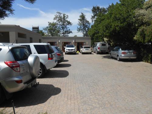 a row of parked cars parked in a driveway at Dilisca Guesthouse in Durbanville