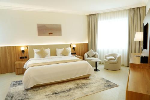 a bedroom with a large bed and a large window at Al HAYAT PALACE HOTEL in Sharjah