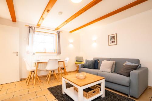 a living room with a couch and a table at Alte Scheune Koserow bei Baltic Home in Koserow