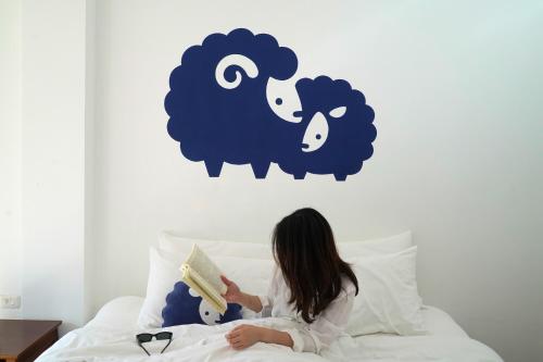 a little girl sitting on a bed reading a book at Kokotel Khao Lak Montana in Khao Lak