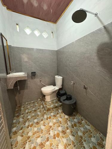 a bathroom with a toilet and a shower at Asim Paris Guesthouse & jungle trekking in Bukit Lawang