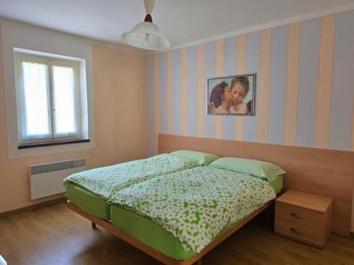 a bedroom with a bed and a picture on the wall at Casa Ilde in Palagnedra