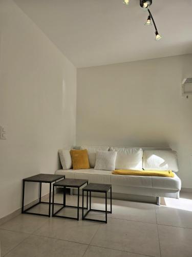 a living room with a white couch and two tables at Casa Chiara in Cavergno