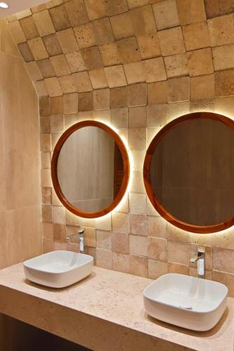 two sinks in a bathroom with two mirrors at JAZ Amaluna - Adults Friendly 16 Years Plus in Uroa