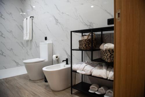 a white bathroom with a toilet and a sink at Casa Avó Libânia in Murça