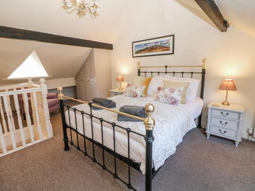 a bedroom with a bed and a crib at Corner Cottage in Buxton