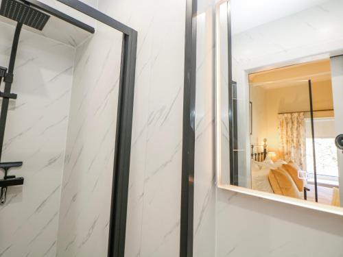 a mirror on the wall of a bathroom at Corner Cottage in Buxton