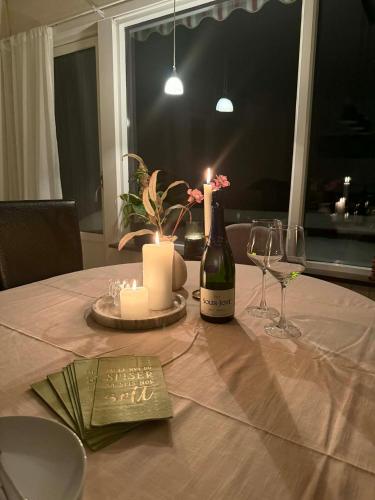a table with a bottle of wine and a candle at Koselig feriehus ved sjøen - Skjevikstranden in Steinkjer