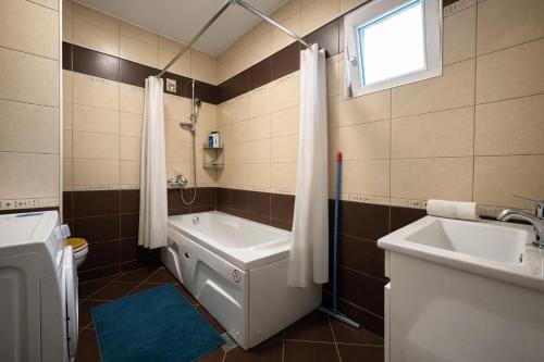 a bathroom with a tub and a toilet and a sink at Siera's Penthouse in Prishtinë