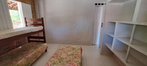 a room with a bench and a chair and shelves at Recanto do Pontal in Japaratinga