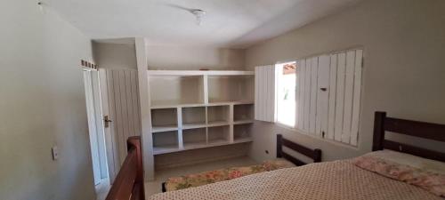 a bedroom with a bed and a window at Recanto do Pontal in Japaratinga
