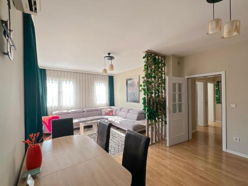 a living room with a table and a couch at Siera's Penthouse in Prishtinë