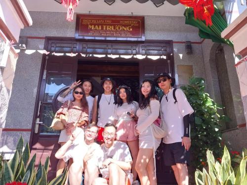 a group of people posing in front of a building at Homestay Mai Trường Cù Lao Chàm in Tân Hiệp