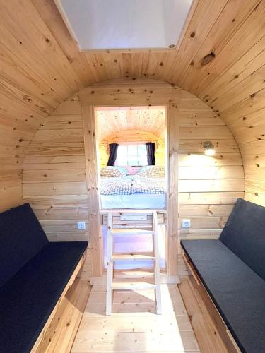 a small cabin with a bed and a ladder in it at Campingfass im Naturresort Weserinsel in Langwedel