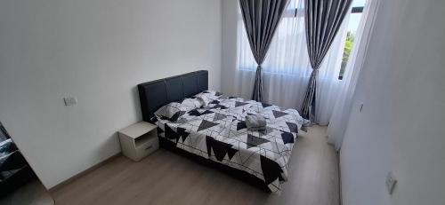 a bedroom with a bed with a black and white comforter at D'Millenia Residences Steady in Kota Samarahan