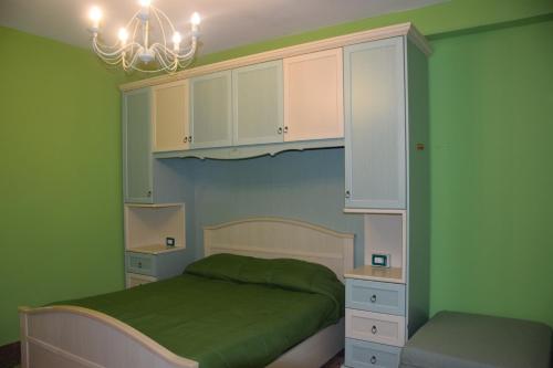 ローマにあるAppartamenti Romolo E Remoの緑のベッドルーム(ベッド1台、シャンデリア付)