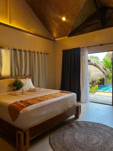 a bedroom with a bed and a large window at La Colonial Resort - Wellness Access Included in El Nido