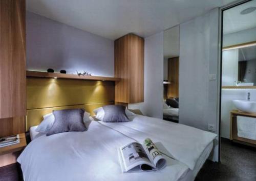 1 dormitorio con 1 cama blanca grande y lavamanos en Victoria Mobilehome Tortoreto Lido, en Tortoreto Lido