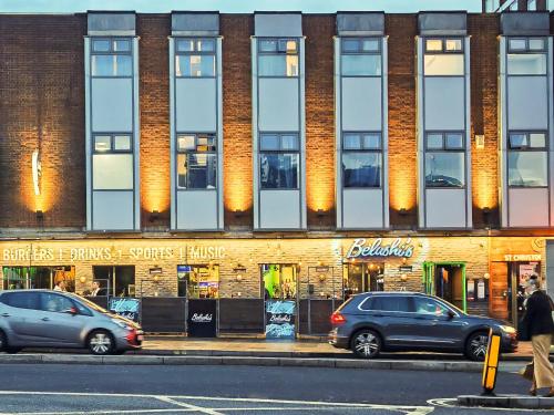 two cars are parked in front of a building at St Christopher's Inn Shepherd's Bush in London