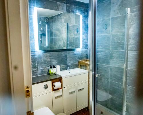 a bathroom with a sink and a shower at Lovely 2 Bedroom B-listed converted Whisky bond in Edinburgh