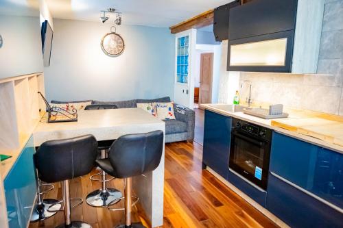a kitchen and living room with a counter and stools at Lovely 2 Bedroom B-listed converted Whisky bond in Edinburgh