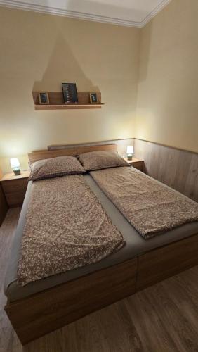 a bedroom with a large bed with two pillows at Lotti City Apartman in Békéscsaba