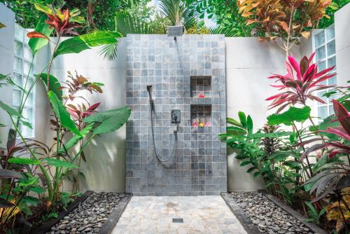 a shower stall in a garden with plants at Villa Mata Hari in Panji